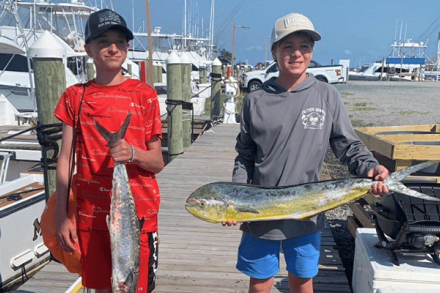 Two Kids holding catch on the dock
