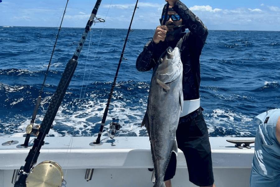 Client holding a amberjack while offshore on a charter