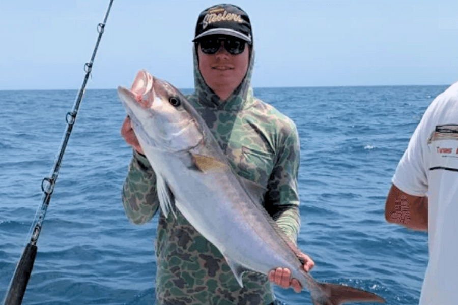 Client holding a amberjack while offshore on a charter